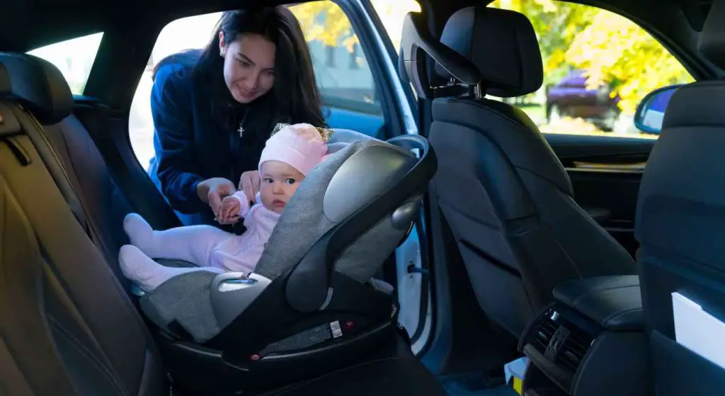 Mãe colocando bebê na cadeirinha